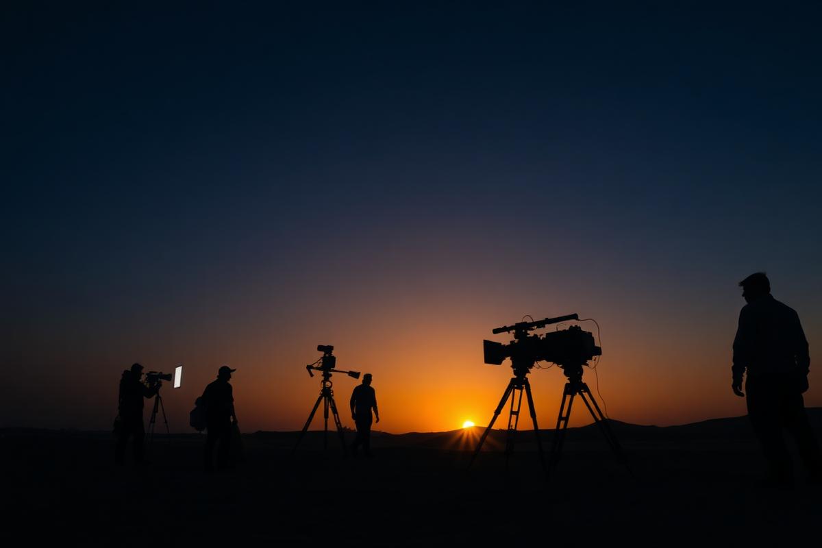 Film crew shooting on location in the Egyptian desert at dusk